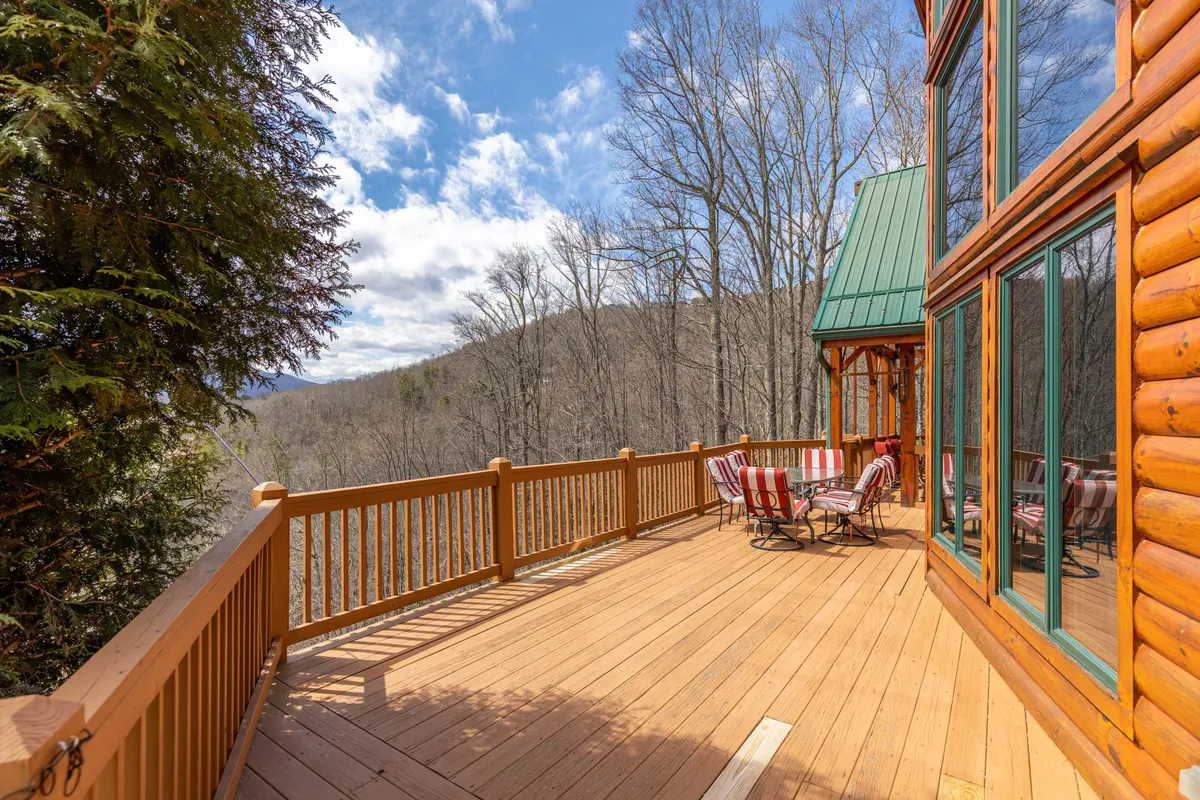 This image presents a spacious outdoor deck with striped chairs arranged to take in a panoramic mountain view. The area invites group relaxation and socializing, with enough space for family members of all ages to gather and enjoy the outdoors together.